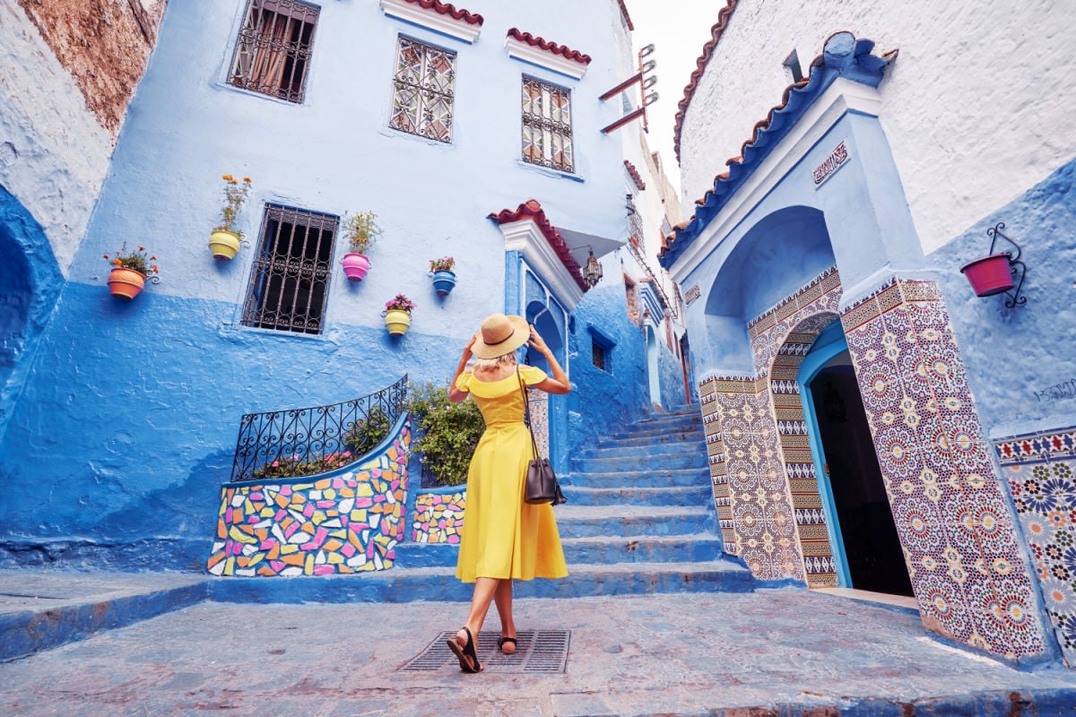 woman explores colorful city of chefchaouen in morocco